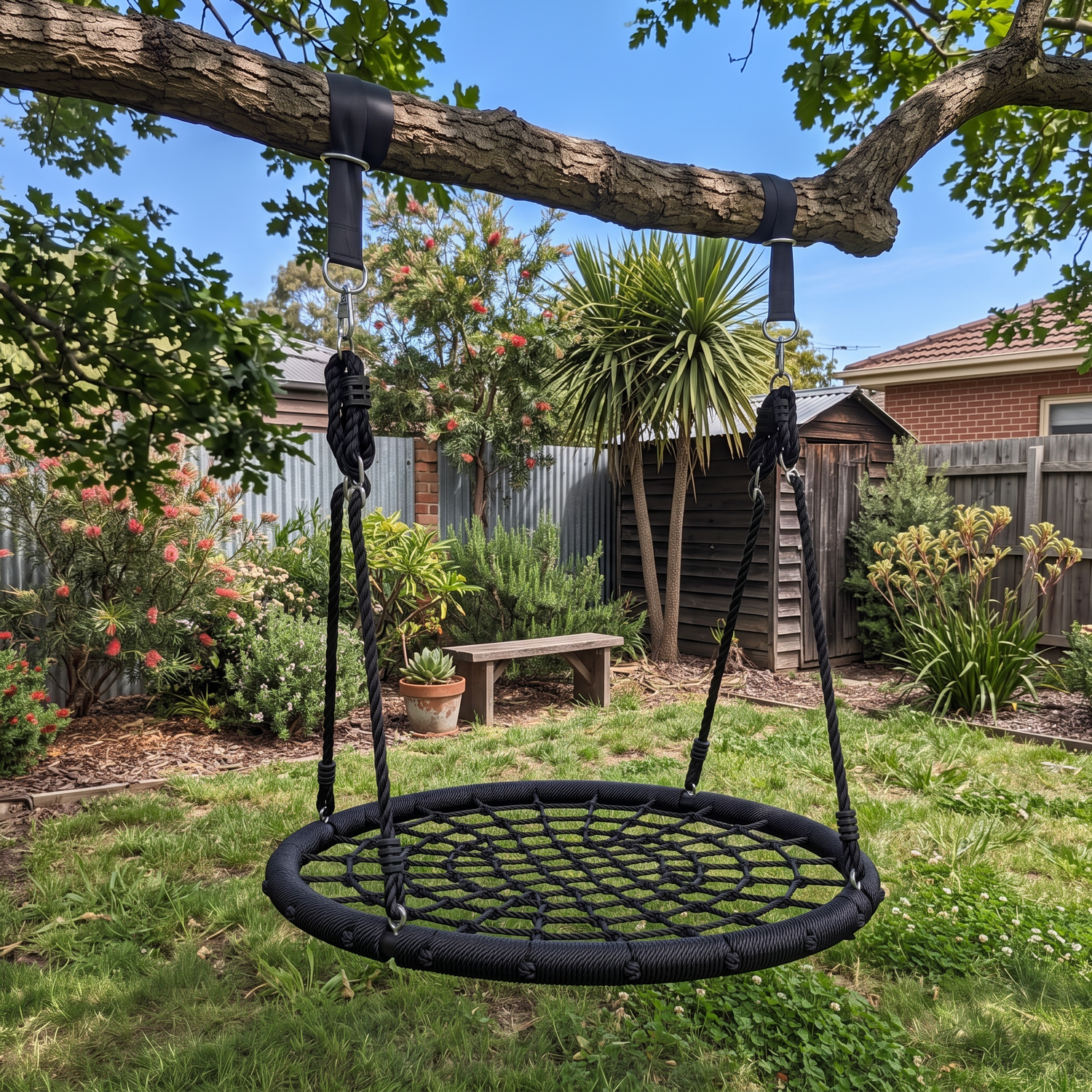 Nest swing hanging from a tree in a backyard from tree straps