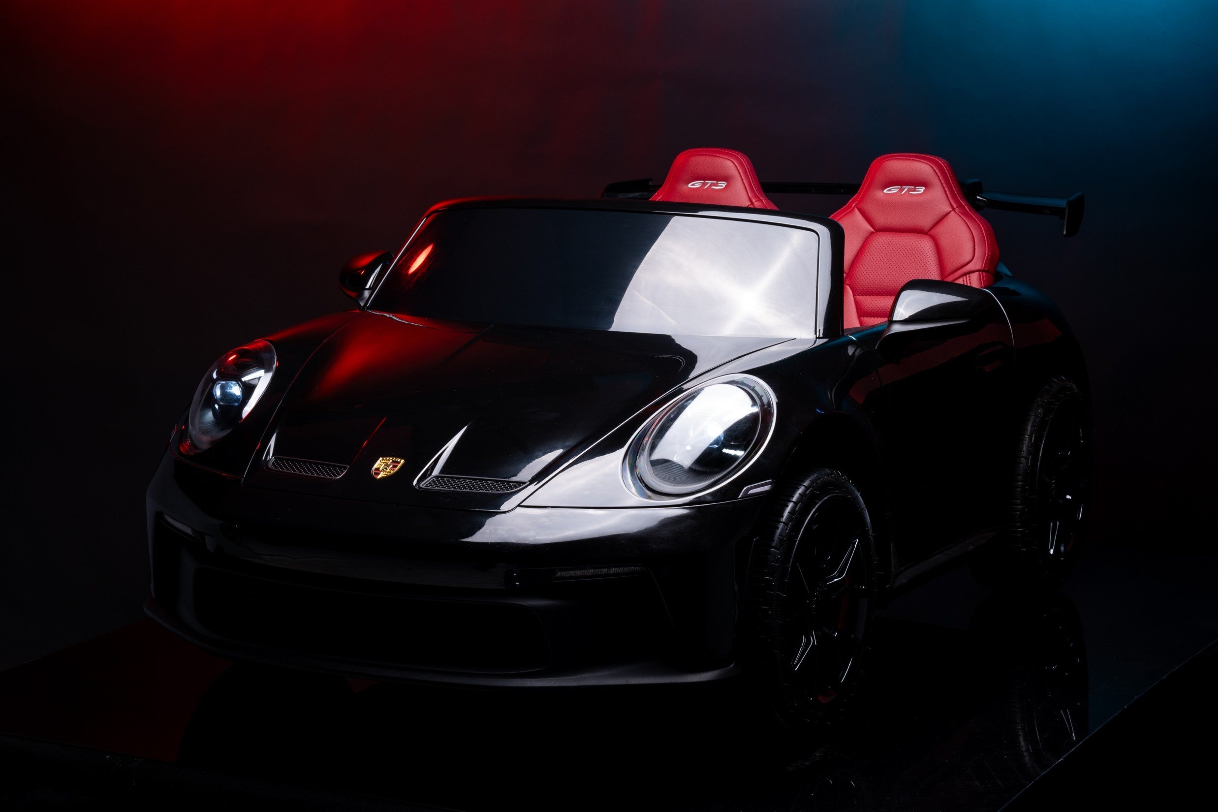Black toy car with red seats on a dark background