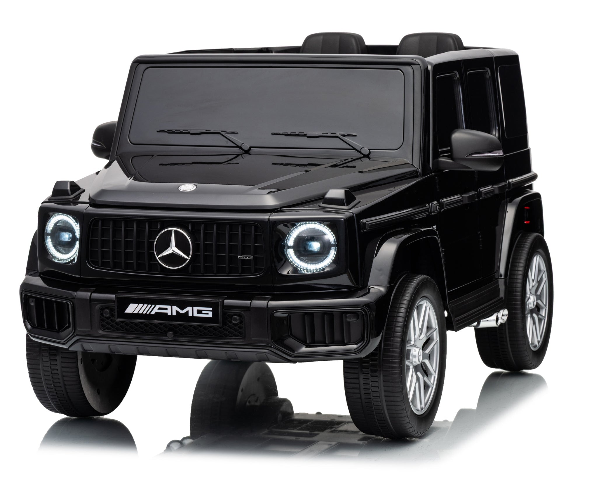 A black Mercedes-Benz G-Class style ride-on toy car with AMG branding, shown from a three-quarter front angle on a white background with a faint reflection underneath.