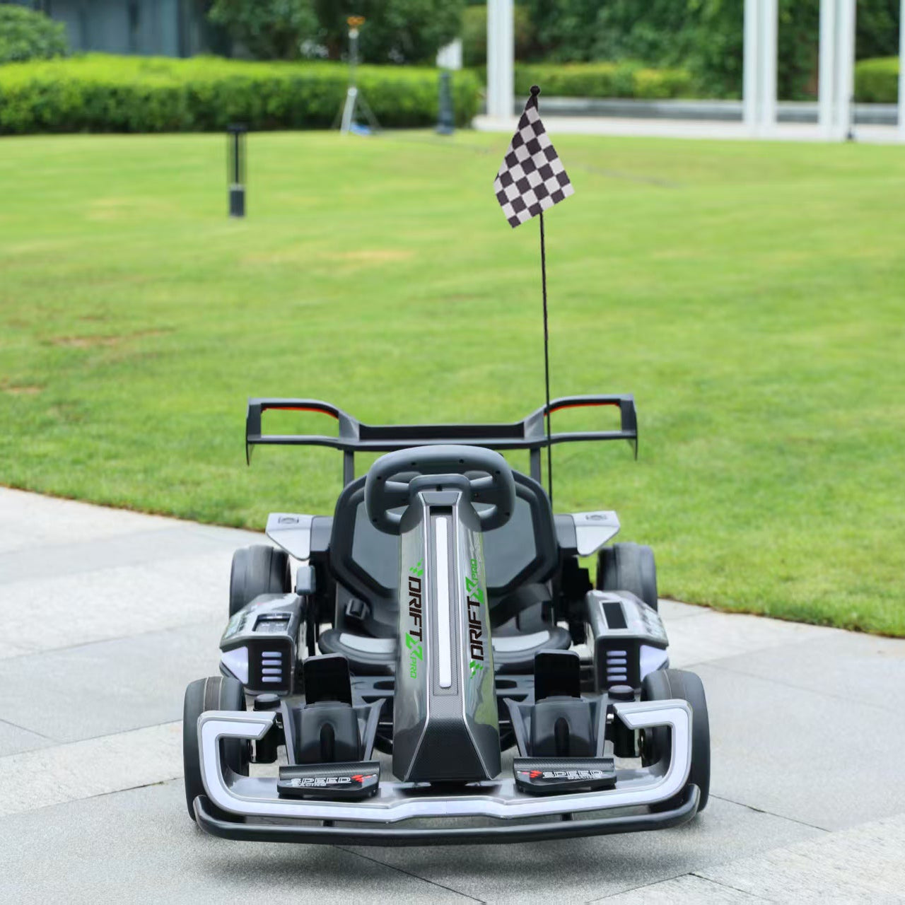 Drift X Pro go-kart on a paved area with grass and a building in the background