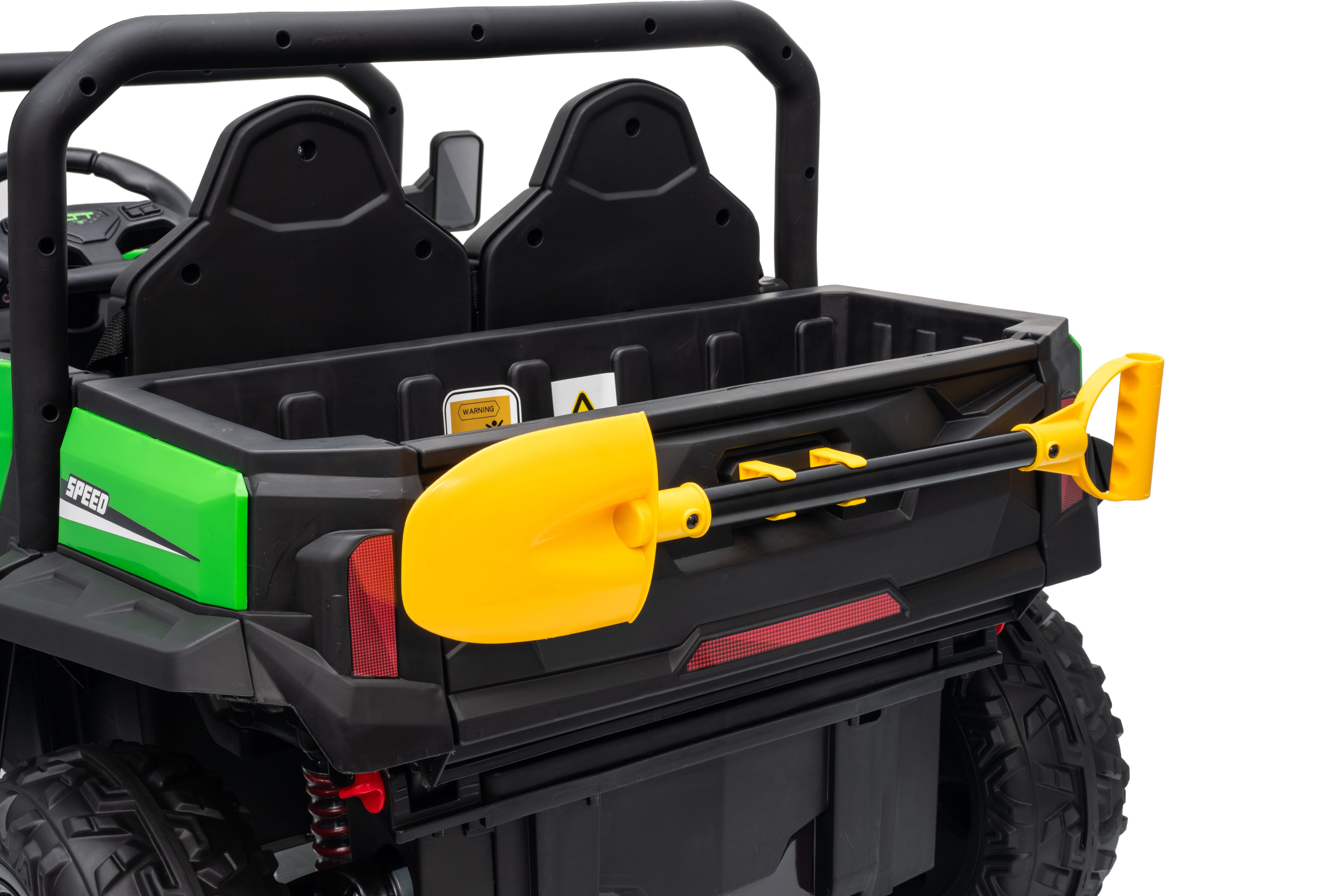 Back of a toy utility vehicle with a yellow shovel in the cargo bed on a white background