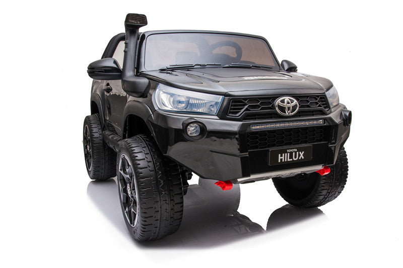 Front view of the Toyota Hilux 4WD kids’ electric ride-on with illuminated LED headlights and light bar.