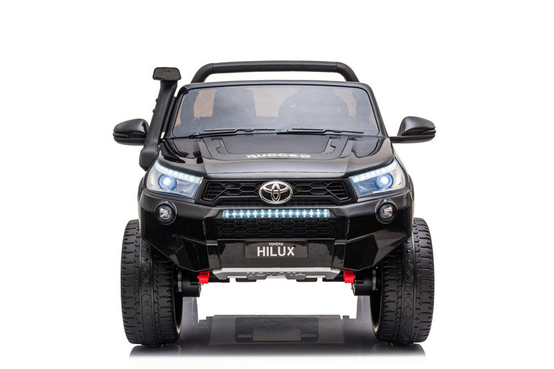 Front view of the Toyota Hilux 4WD kids’ electric ride-on with illuminated LED headlights and light bar.