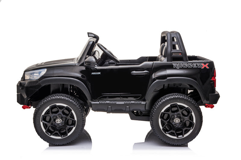 Side profile of the licensed Toyota Hilux Rugged X 4WD kids’ ride-on car showing lifted suspension and doors