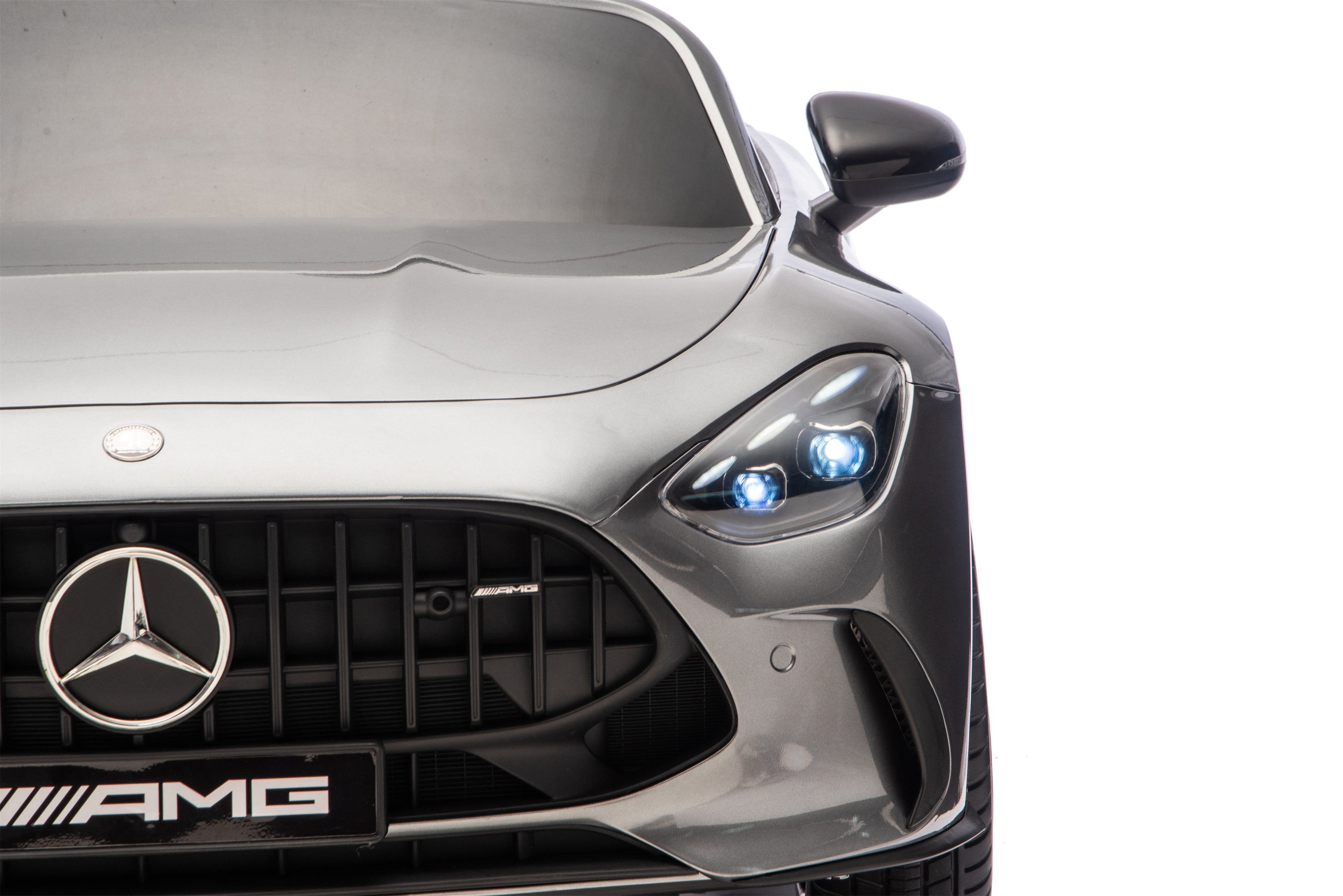 Close-up of a Mercedes-AMG car front with logo and 'AMG' badge.