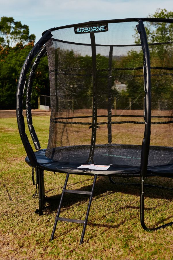 Trampoline with safety net on grassy field