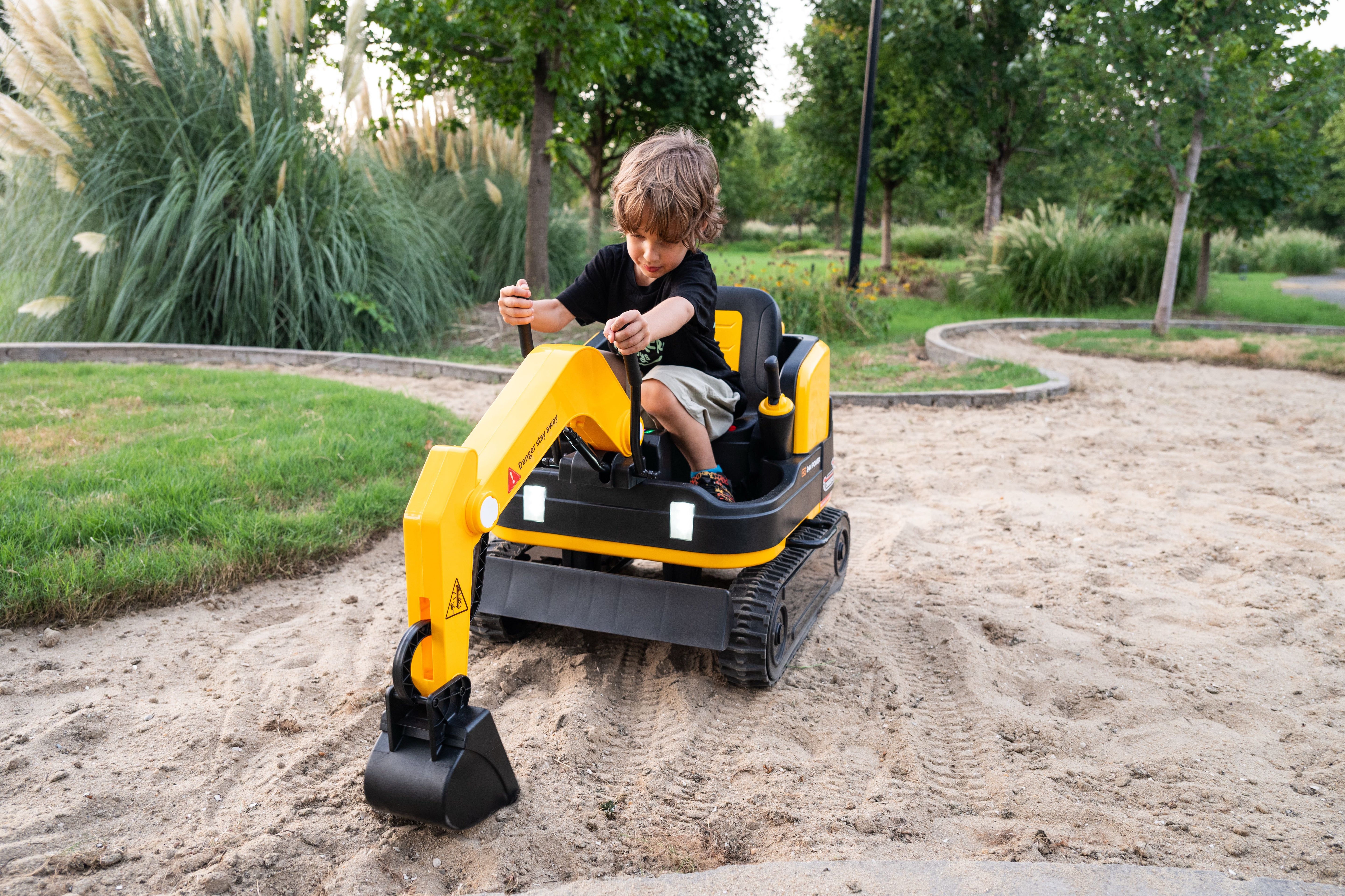 Child playing with a toy excavator in a park setting