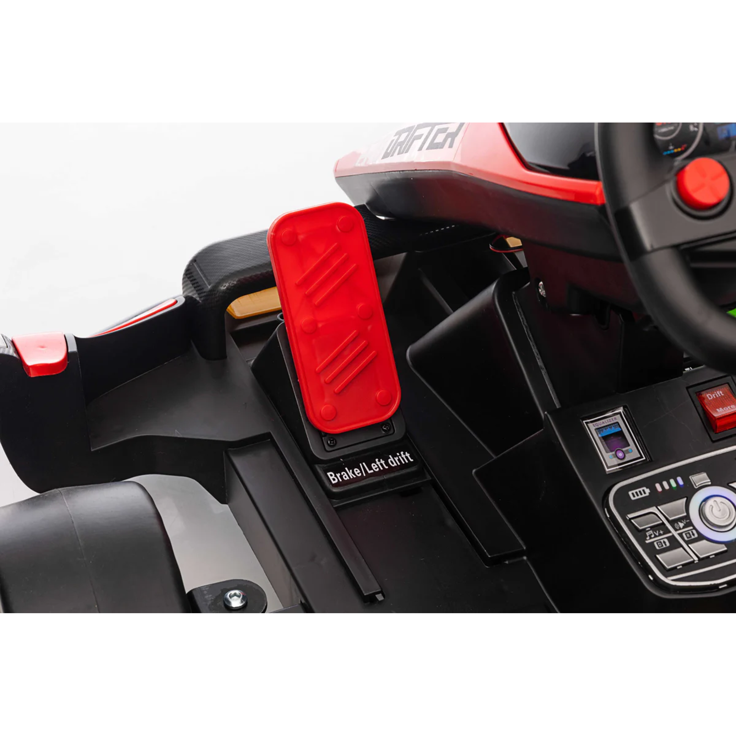 Close-up of a toy car's steering wheel and dashboard with a red brake pedal.