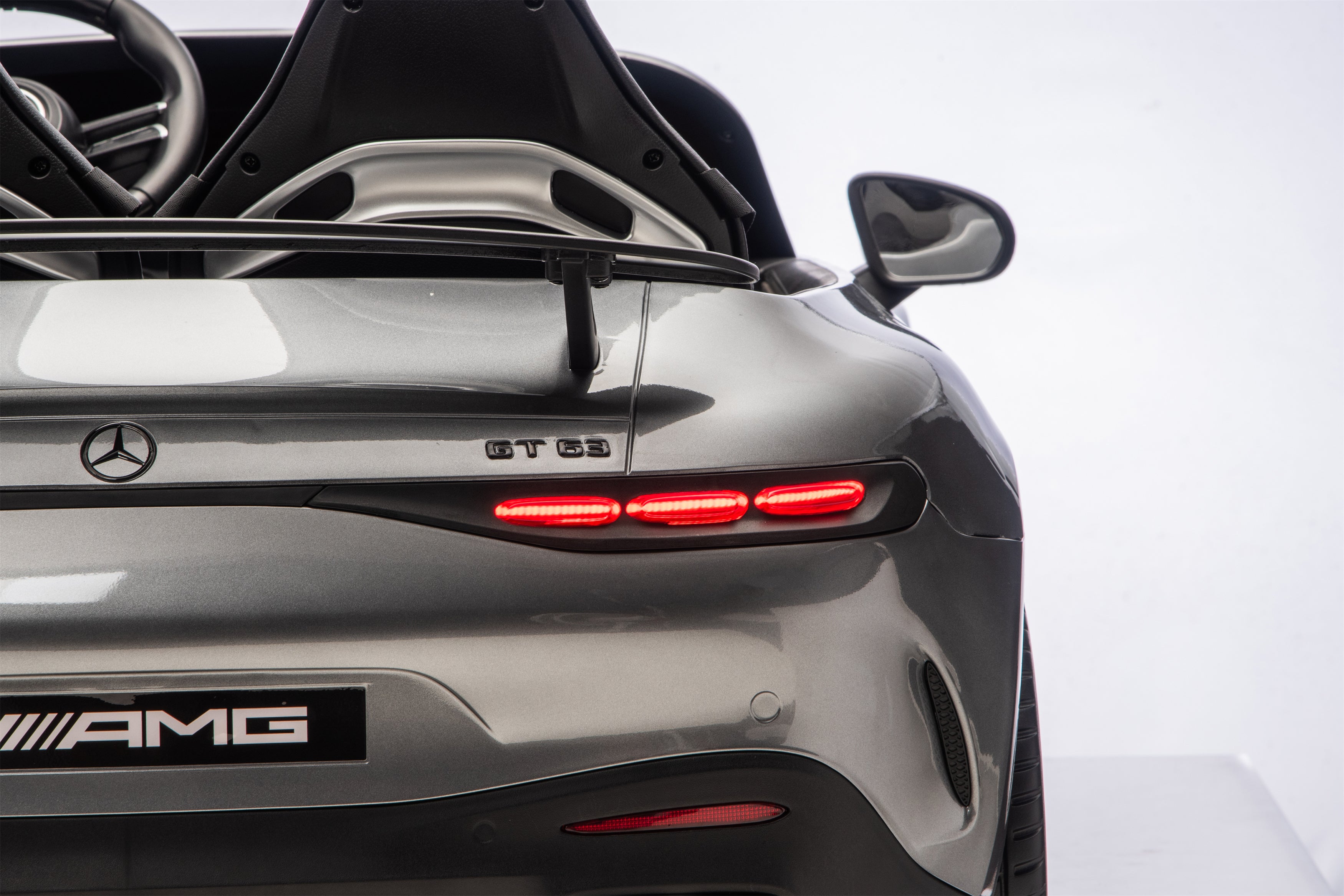Back view of a Mercedes-AMG car with open trunk on a white background