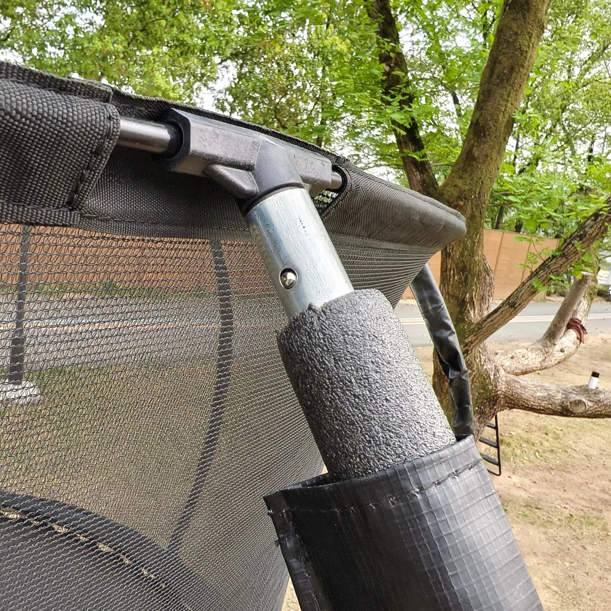 Close-up of a car canopy with a tree and outdoor setting in the background