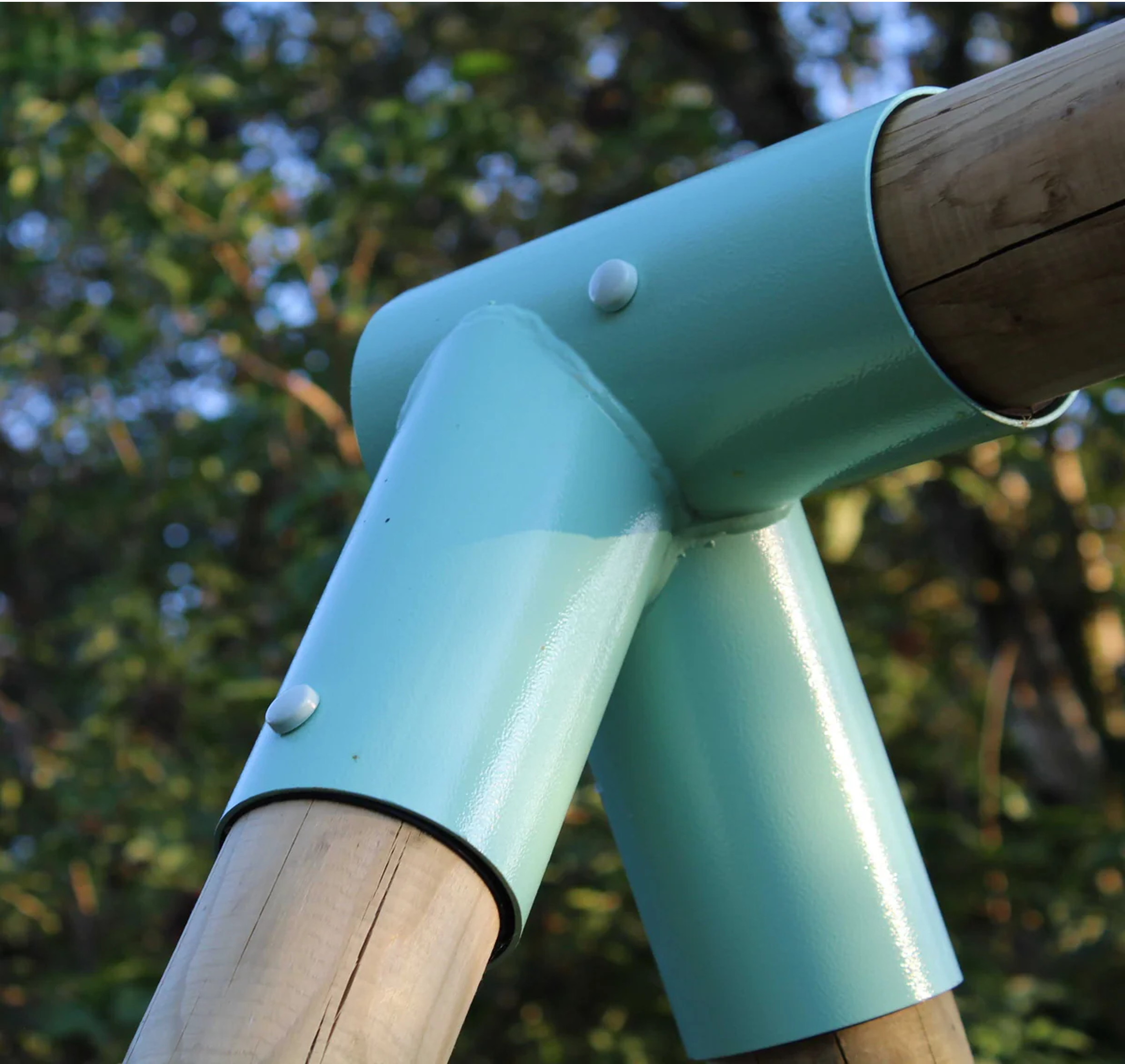 Teal plastic sleeve on a wooden post with trees in the background