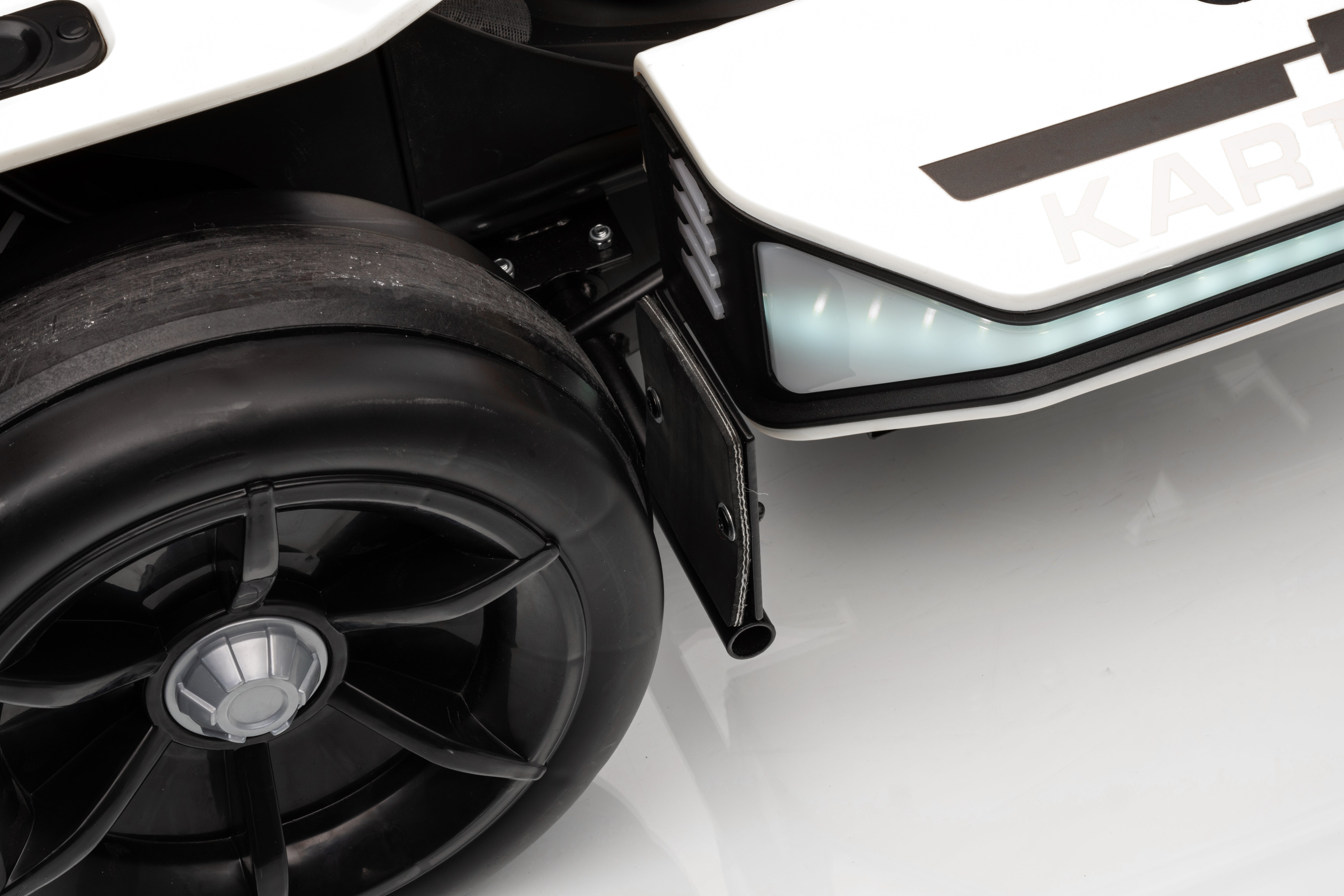 Close-up of a black wheel and car body with 'Kart' branding on a white background