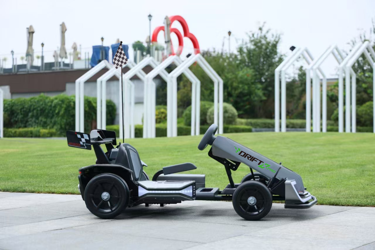 Children's go-kart with 'DRIFT' branding on a grassy area with playground equipment in the background.