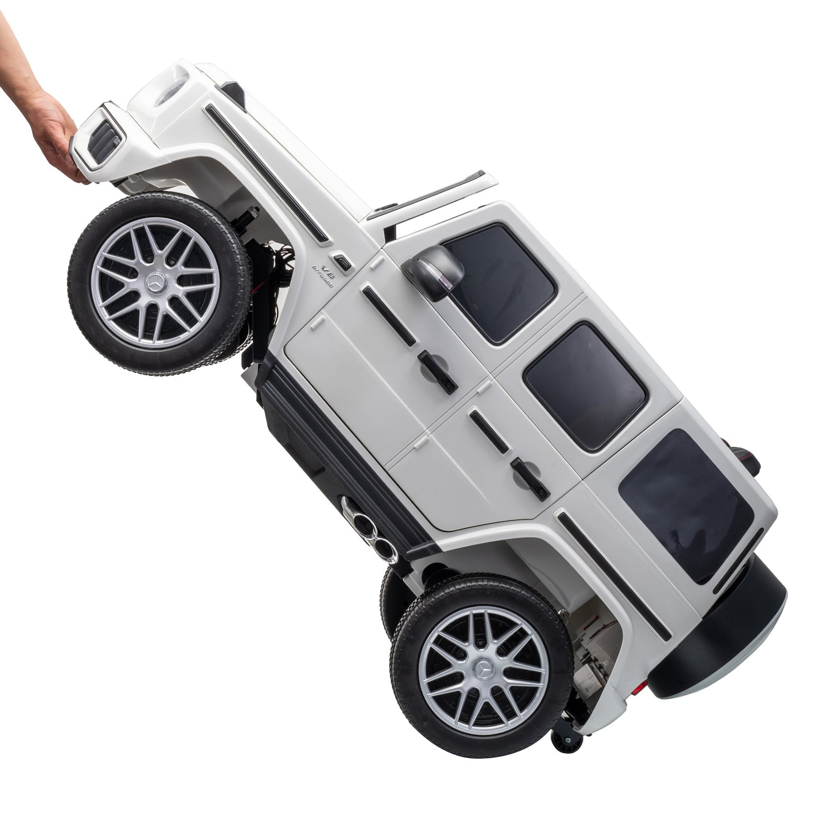 A white and black toy SUV vehicle being held by a person's hand against a plain white background.