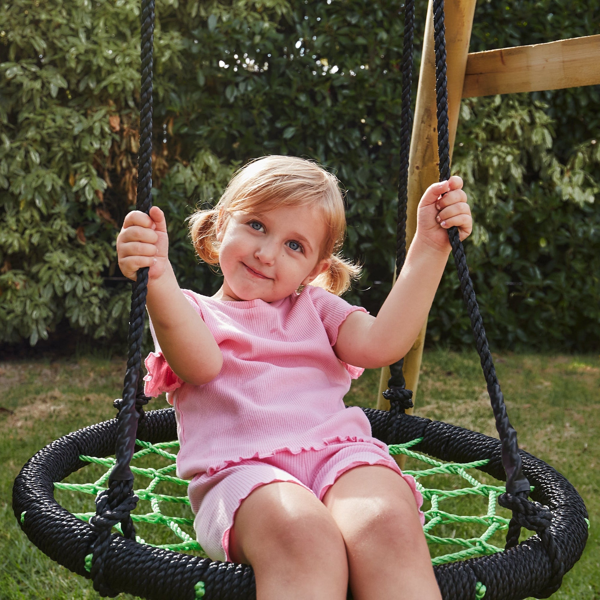 Child on a swing set in a garden