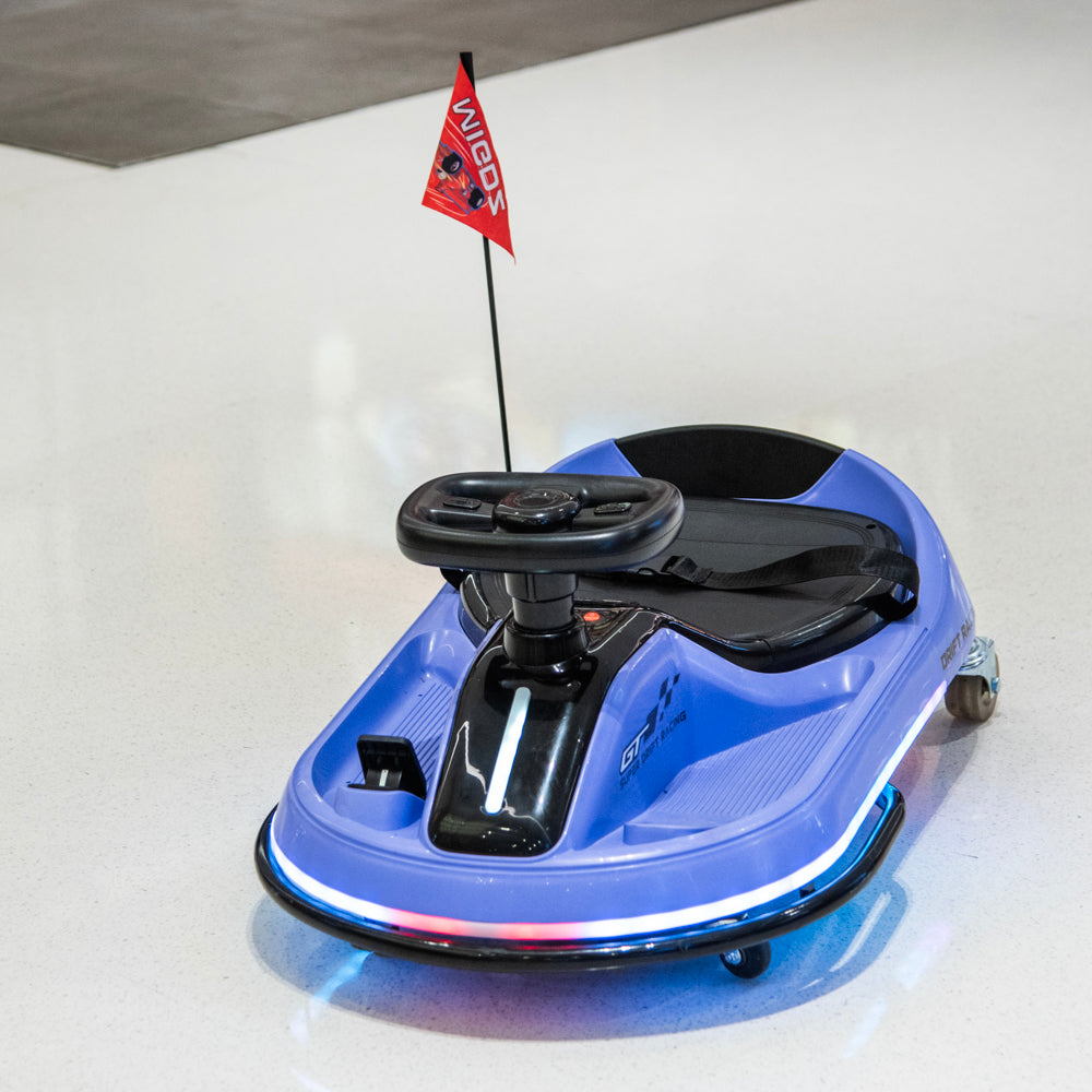 A blue and black kids' electric go-kart with a small red 'WIGOO' brand flag on a pole, photographed on a clean white floor.