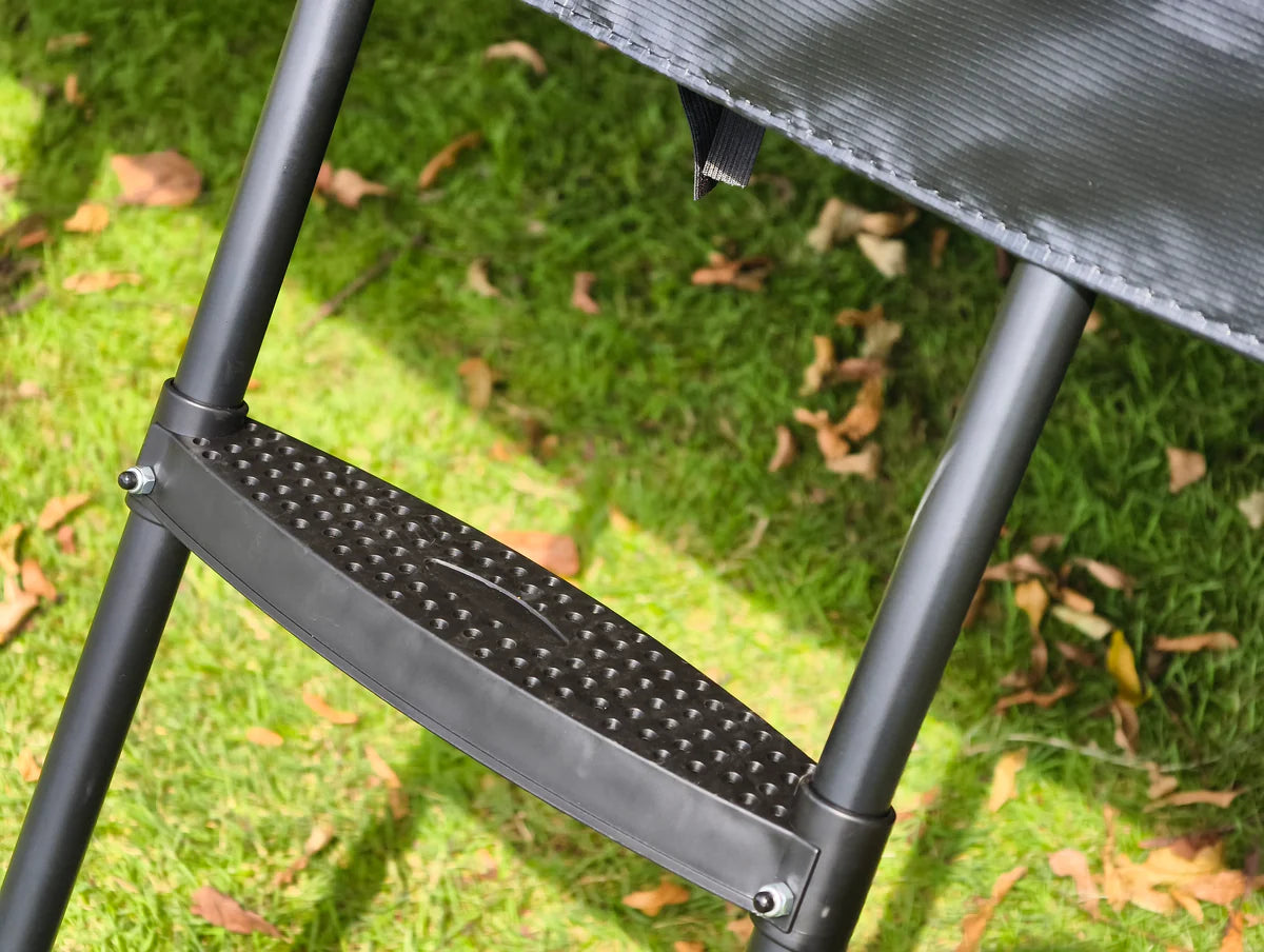 Step stool on grass with a trampoline in the background