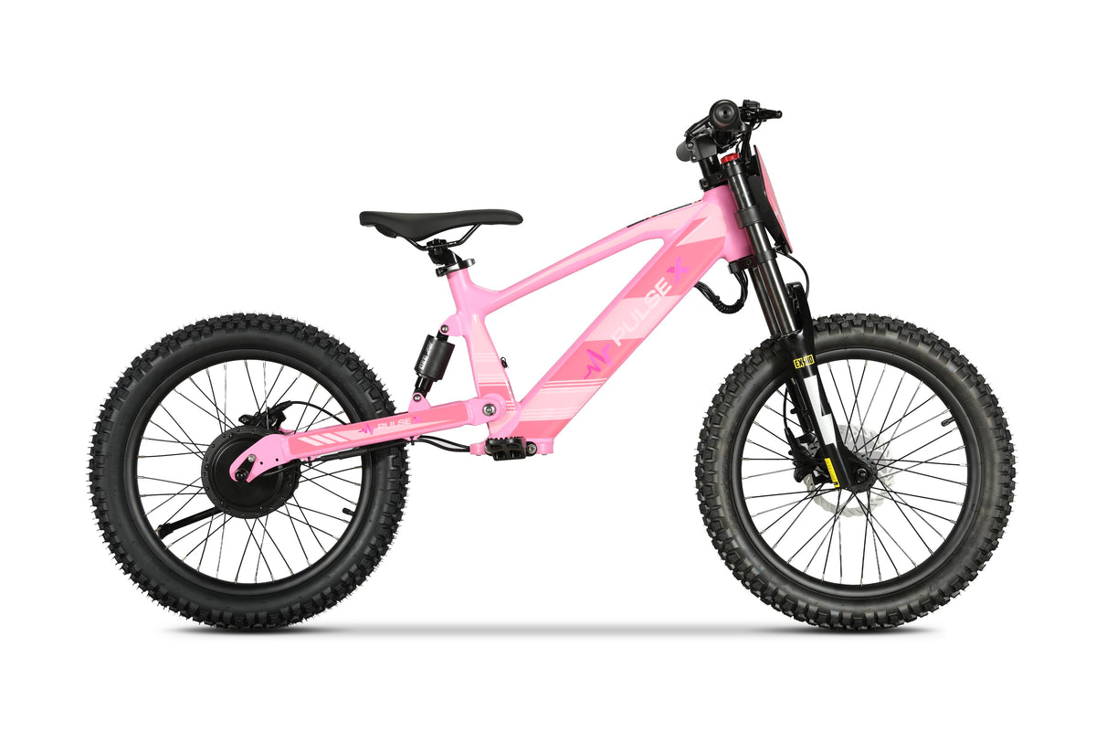 A pink electric children's bicycle with fat tires, a black saddle, and a black front suspension fork, shown from a side profile on a white background.