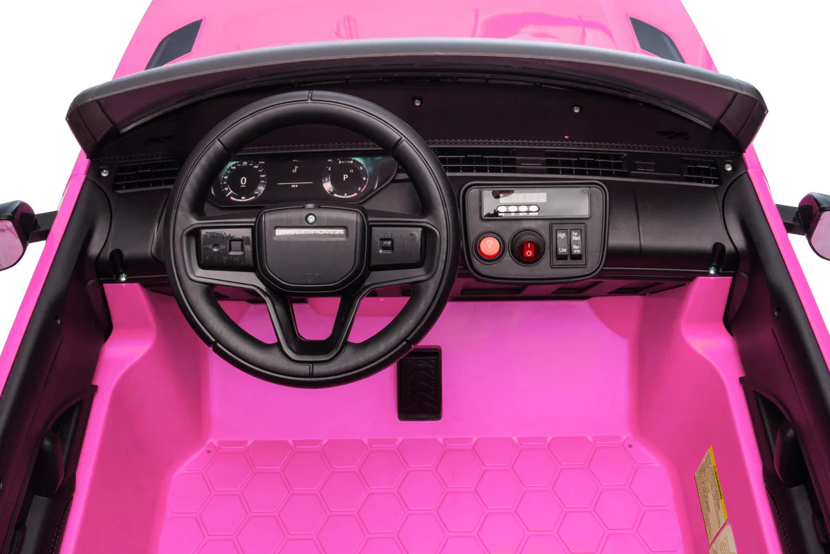 Close-up of a pink toy car's interior with steering wheel and dashboard.