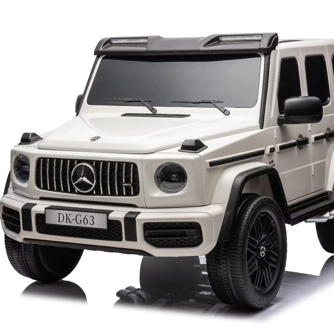 A cream-colored Mercedes-Benz G-Class style toy SUV with black wheels, tires, and roof, shown from a three-quarter front angle on a white background with a reflection.