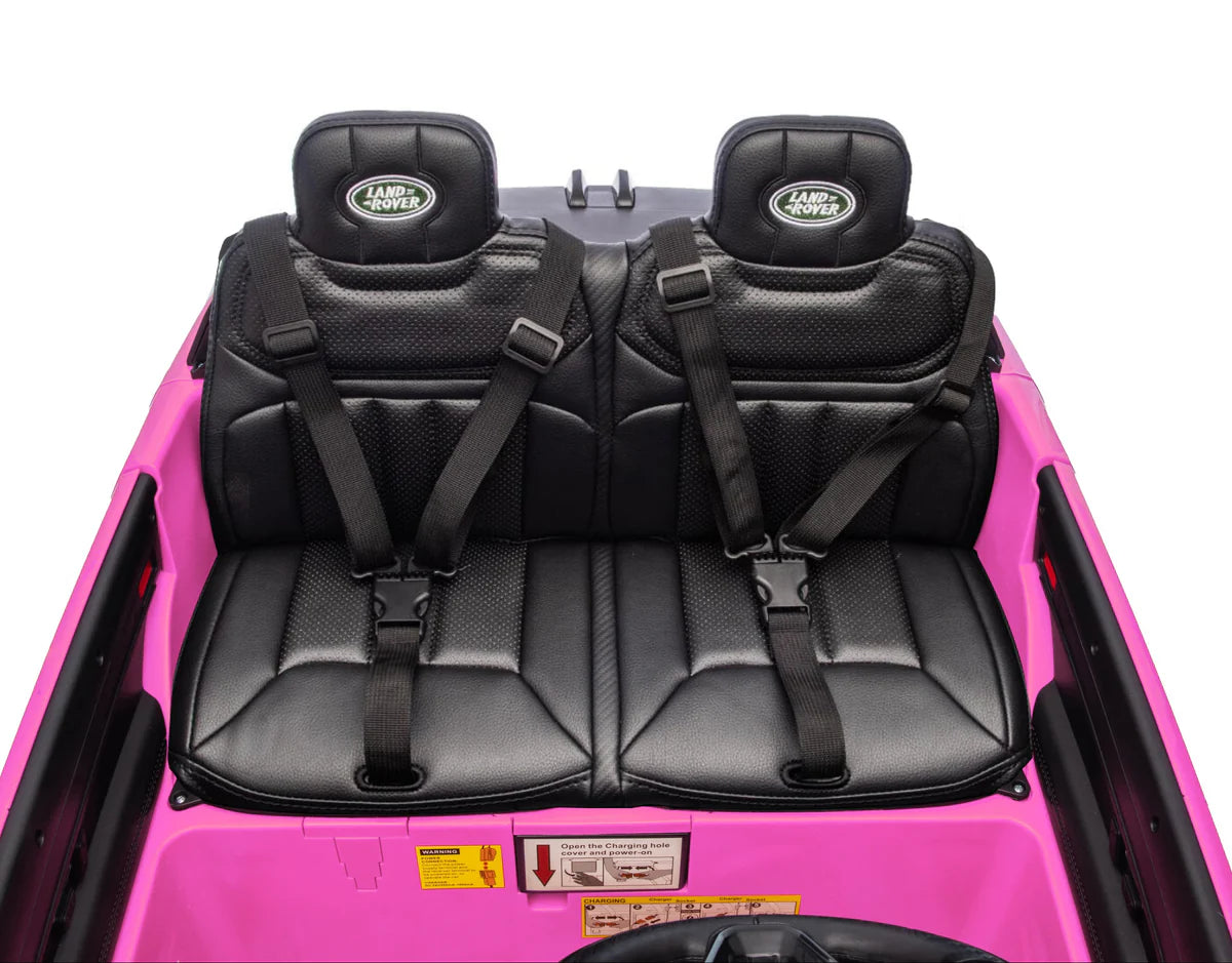 Black seats with seat belts in a pink vehicle on a white background