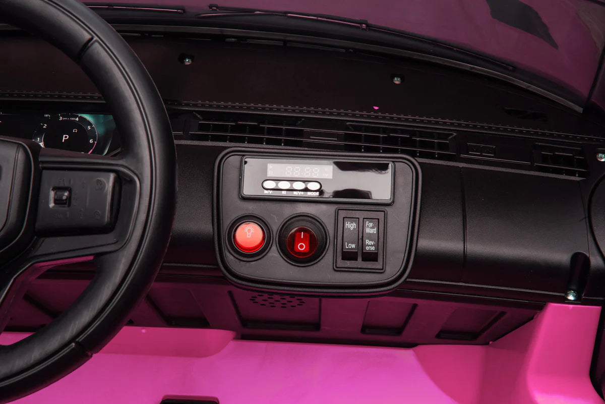 Close-up of a car's dashboard with steering wheel and control panel on a pink interior.