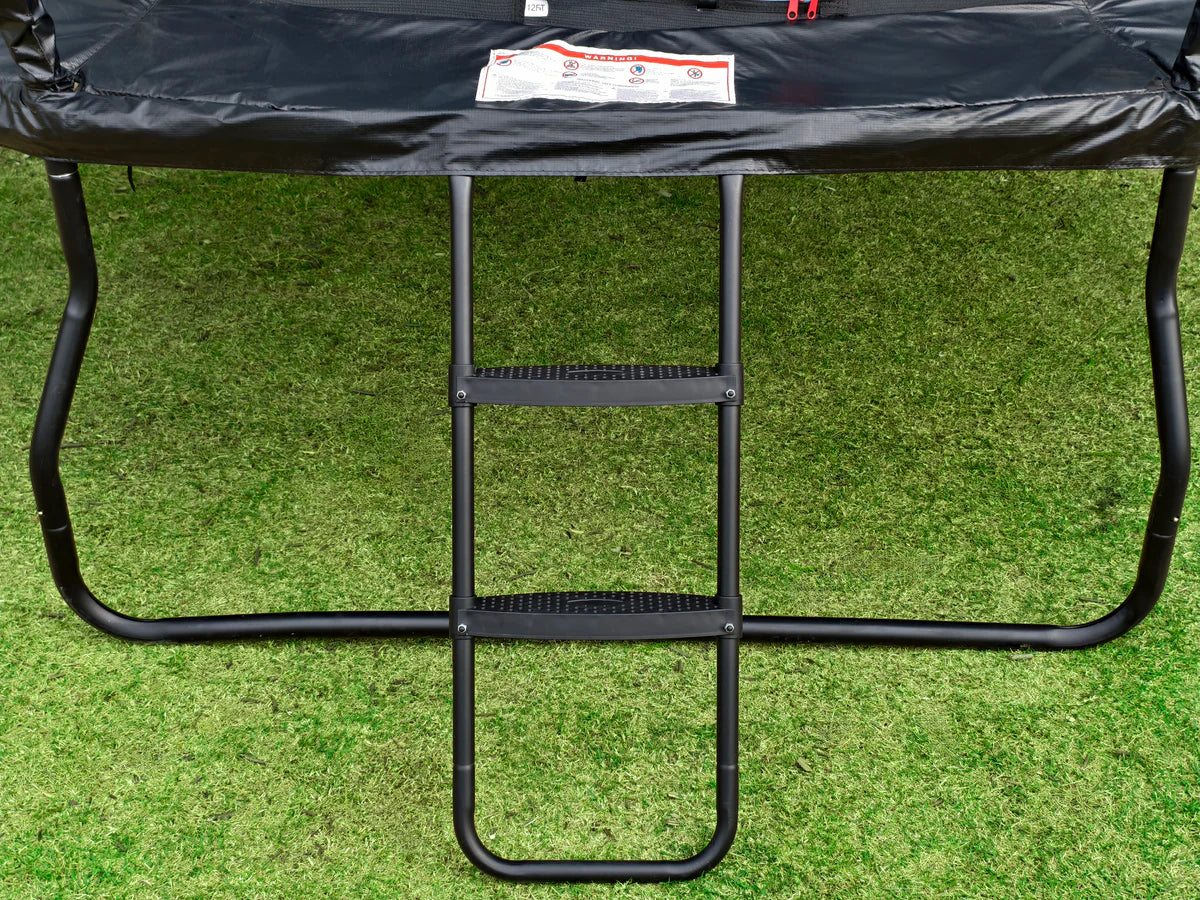Black trampoline with a ladder on a grassy background