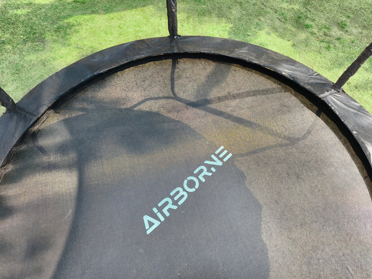 Close-up of a trampoline with 'Airborne' branding on a grassy background